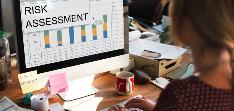 Person working on a computer displaying a risk assessment chart, emphasizing business compliance and legal guidance for small businesses.
