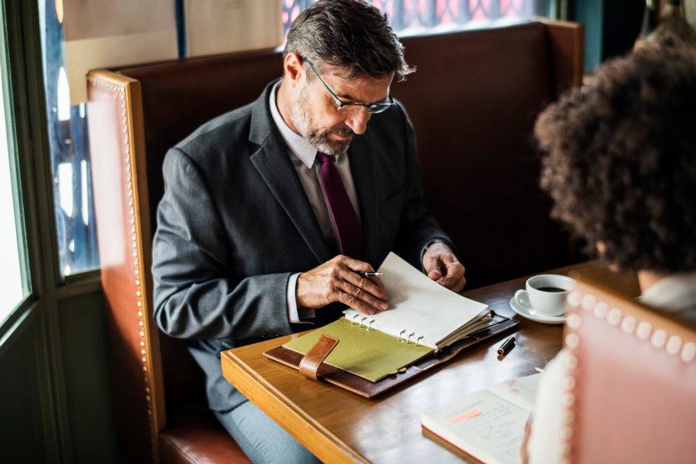 Business attorney reviewing documents in a café, emphasizing LLC formation and legal guidance in New Jersey.