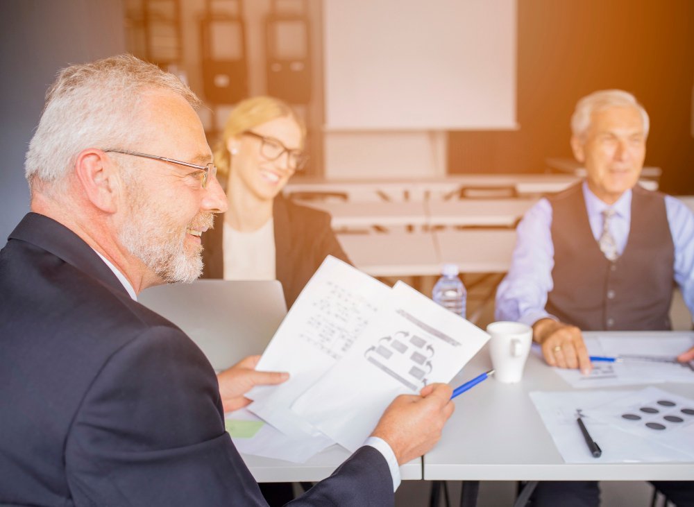 Business professionals discussing due diligence documents in a meeting, emphasizing legal services for business transactions in New Jersey.