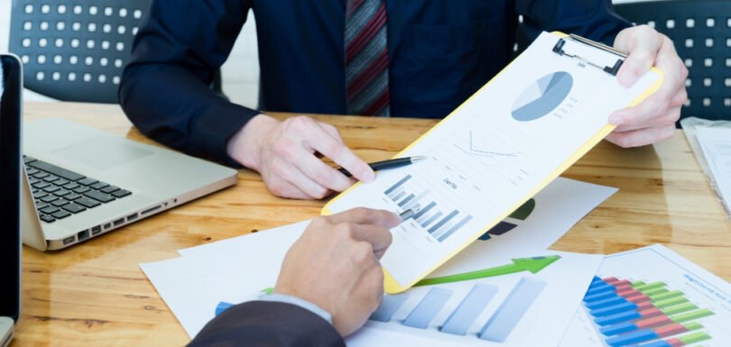 Business professionals reviewing financial charts and graphs during a consultation, highlighting the importance of written agreements and effective negotiation in partnership disputes.