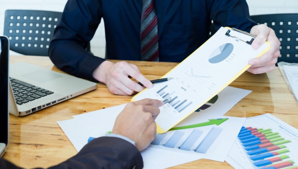 “Business Legal Risk Analysis Services – New Jersey Business Law Firm” Business consultation meeting with charts and graphs discussing investment risks in tech industry.