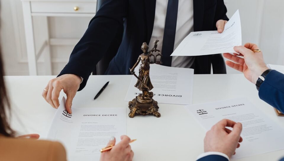“Employment Contracts Attorney – Business Law Firm in New Jersey” Hands exchanging legal documents labeled "Divorce Decree" during negotiations, with a statue of Lady Justice on the table, symbolizing legal proceedings and partnership disputes.
