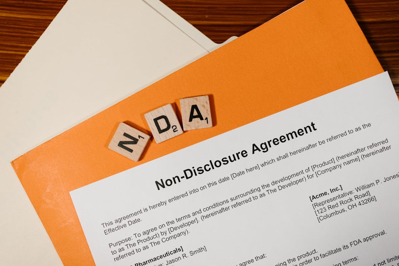 Non-Disclosure Agreement document with NDA letters and orange folder, representing legal confidentiality services for businesses in New Jersey.