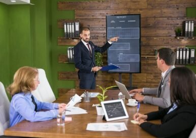 businessman-suit-pointing-charts-tv-screen-meeting-with-his-colleagues-leadership-meeting-conference-room_482257-31221