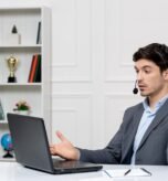 customer-service-cute-guy-grey-suit-with-computer-headset-waving-hands-videocall_140725-164277
