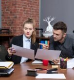 front-view-young-busy-confused-clerical-workers-discussing-one-issue-documents-office_140725-106003