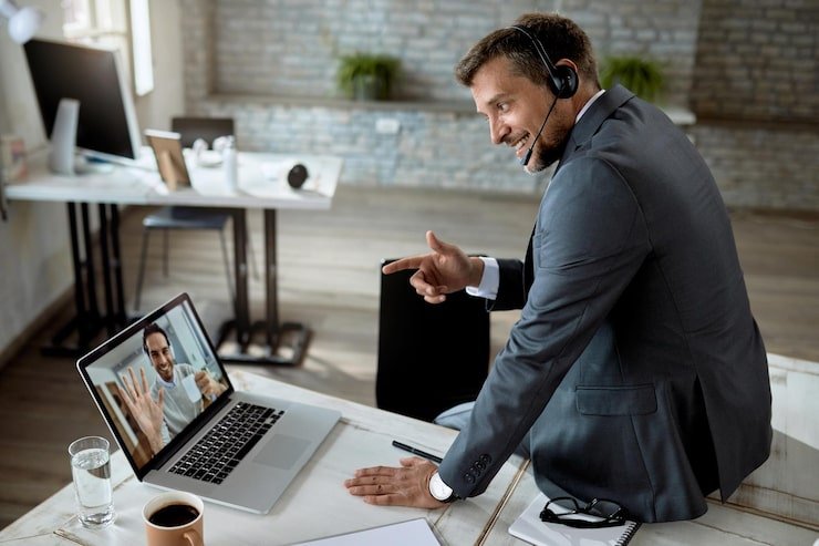 happy-businessman-using-laptop-while-having-online-meeting-with-his-coworker-office_637285-6776