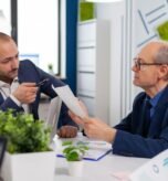 senior-entrepreneur-discussing-with-coworker-holding-documents-conference-briefing-businessman-discussing-ideas-with-colleagues-about-financial-strategy-new-start-up-company_482257-5074
