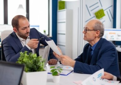 senior-entrepreneur-discussing-with-coworker-holding-documents-conference-briefing-businessman-discussing-ideas-with-colleagues-about-financial-strategy-new-start-up-company_482257-5074